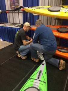 Joe Zellner showing customer an orange Stellar Kayak.