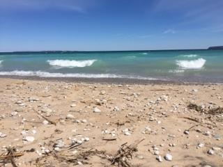 Blue water waves and sandy beaches with rocks near Glen Haven, Michigan.
