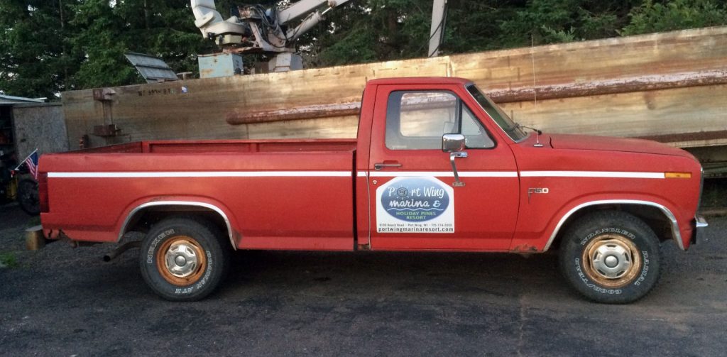 Red 1985 Ford pickup for Port Wing Marina & Holiday Pines Resort.