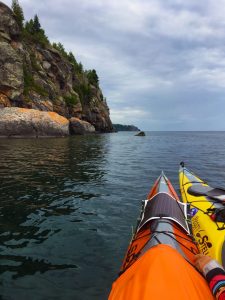Kayaking on Lake Superior with the Split Rock Lighthouse in the distance.