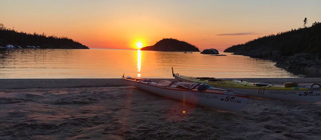Sunset near Marathon Ontario, Canada with kayaks on the beach. 